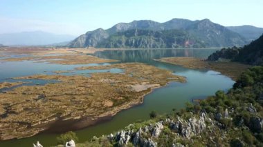 Uzun plaj muhteşem dağları sazlıklar, dalgalı deniz manzarası. İztuzu plajı Mugla, Dalyan köyü, Türkiye. 4K video