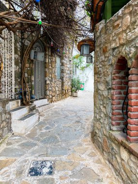 Marmaris 'in güzel sokakları. Türkiye 'nin eski tatil beldesinde beyaz tuğlalı, yeşil bitkili ve çiçekli evler arasında merdivenlerle dar sokaklar
