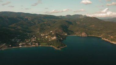 Okyanus mavi dalgalarının insansız hava aracının 4K görüntüsü kayalık bir dağın yüksek uçurumunda kırılıyor. Sahilde tehlikeli deniz dalgaları