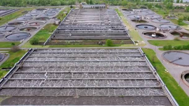 Aerial shot of a wastewater treatment plant and distant skyline. Big city waste processing concept — Stock Video