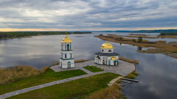 Church on the water in the rays of the rising sun