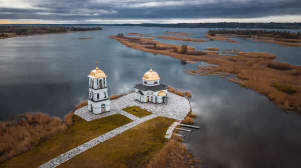 Church on the water in the rays of the rising sun