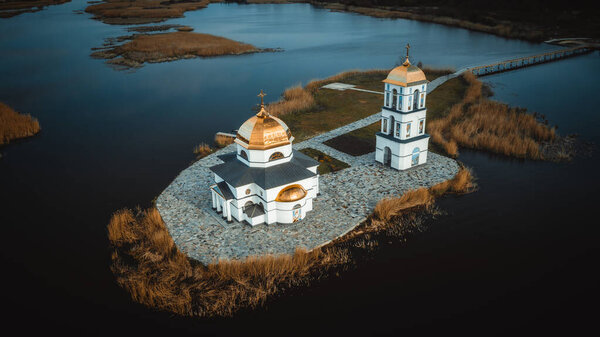 Church on the water in the rays of the rising sun