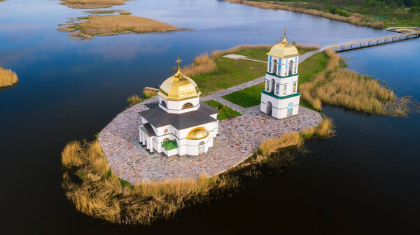 Church on the water in the rays of the rising sun