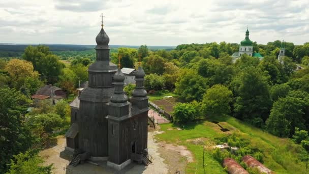 Venkovská krajina létající kolem starého dřevěného kostela. — Stock video