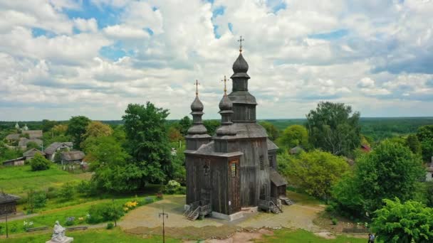 Venkovská krajina létající kolem starého dřevěného kostela. — Stock video