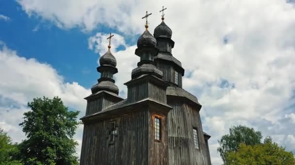 Venkovská krajina létající kolem starého dřevěného kostela. — Stock video