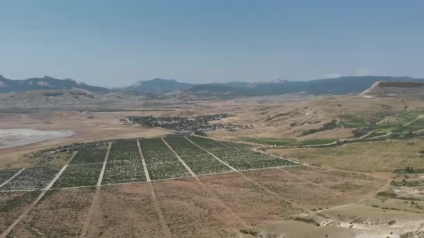 Vuelo aéreo con drones en un pequeño pueblo en un valle de montaña — Vídeos de Stock