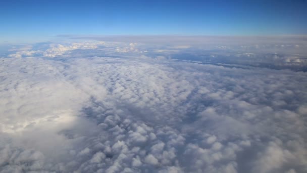 Superbes images de vue aérienne au-dessus des nuages depuis la fenêtre de l'avion avec un ciel bleu. vue depuis la fenêtre de l'avion vers le ciel bleu et les nuages blancs — Video