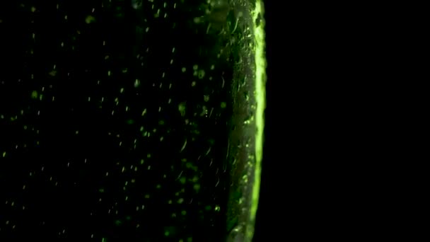 St. Patric Day Green Beer ruotato su sfondo scuro. Bicchiere Misted di birra verde ruotato, primo piano — Video Stock