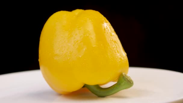 Paprika kuning berputar mengitari dirinya dengan latar belakang gelap. Konsep untuk veganisme dan vegetarian, makanan sehat. — Stok Video
