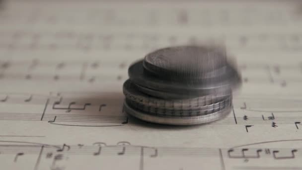 Antiguas monedas antiguas cayendo en la hoja de música de cerca, fondo de dinero financiero. Pago por trabajo creativo — Vídeo de stock