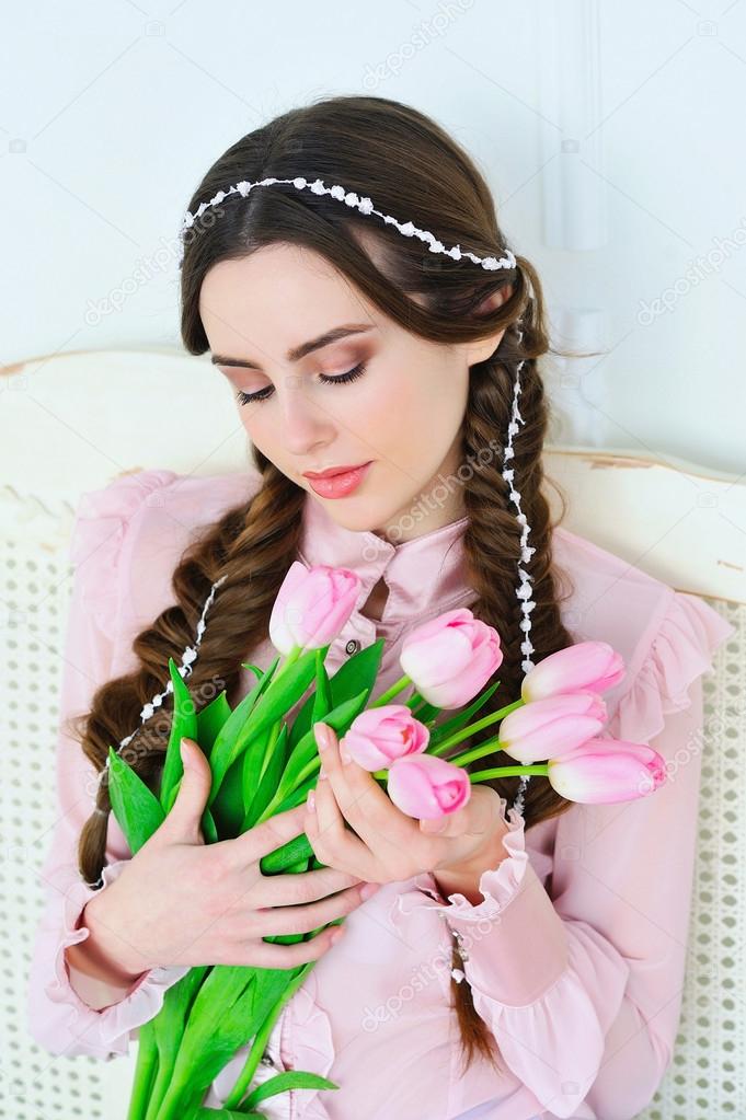 Beautiful young woman with tulips bouquet