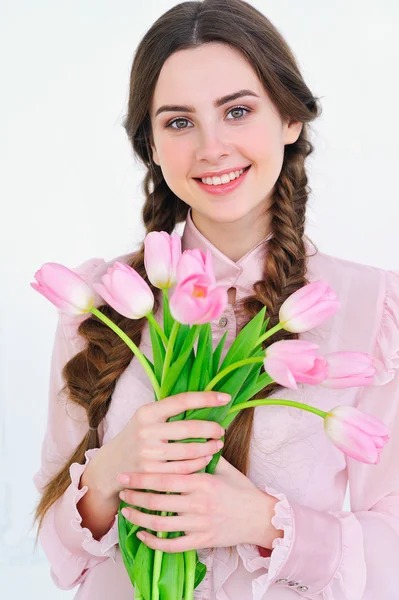 チューリップの花束を持つ少女の笑みを浮かべてください。 — ストック写真
