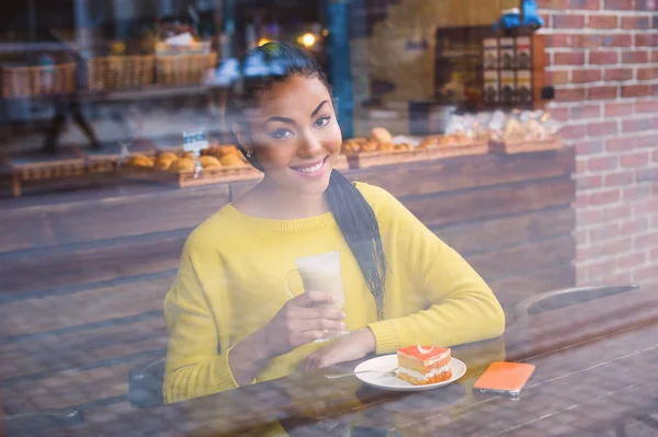 Belle fille avec du café vu par la fenêtre Image En Vente