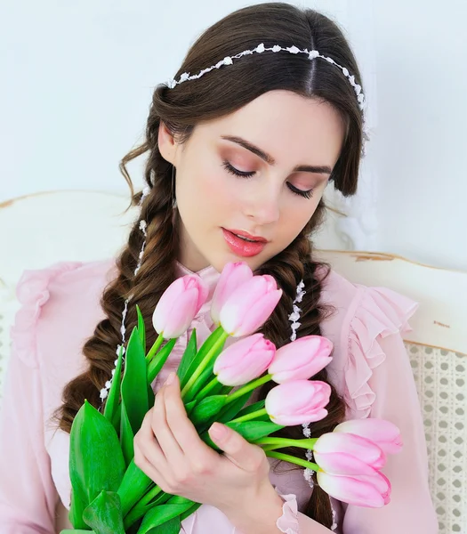 Schattige jonge vrouw poseren met roze tulpen — Stockfoto