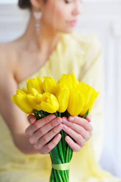 Closeup woman hands holding yellow tulips — Stock Photo, Image