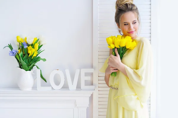 Gorgeous young woman with yellow tulips — Stock Photo, Image