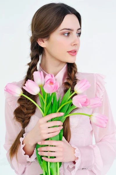 Beautiful young woman with pink flowers bouquet — Stock Photo, Image