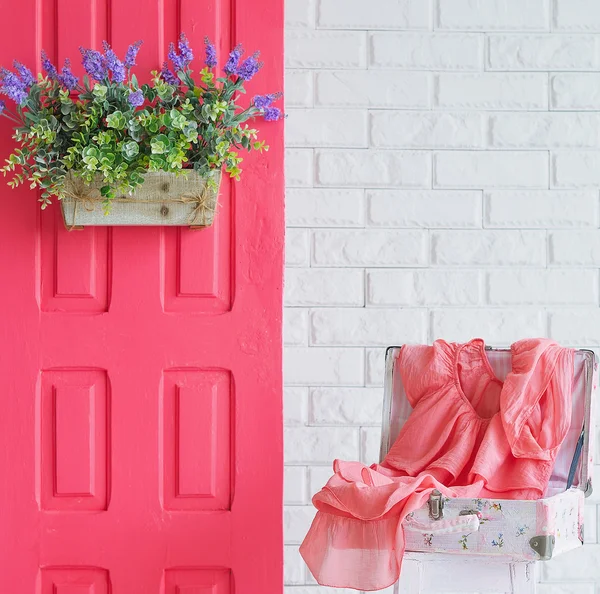 Puerta rosa con flores y un vestido —  Fotos de Stock