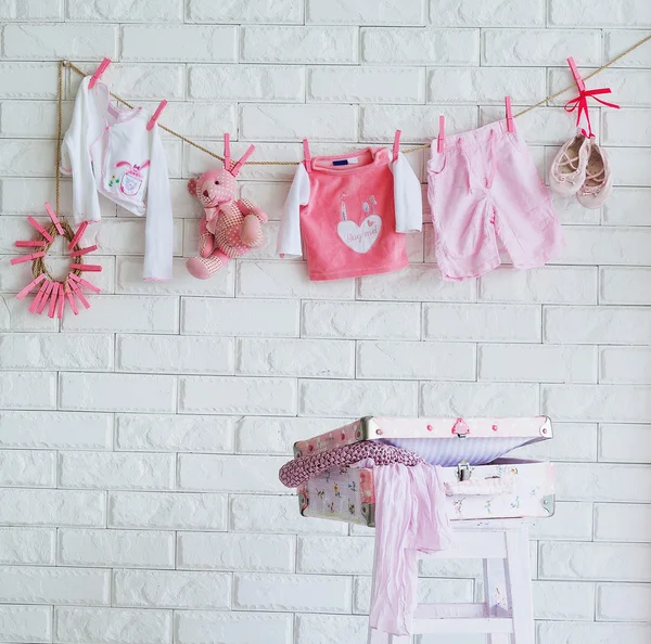 Ropa de bebé colgada en la pared — Foto de Stock