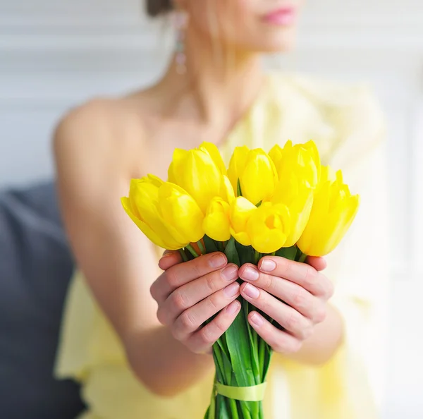 Closeup vrouw handen met gele tulpen — Stockfoto