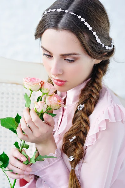 Jonge vrouw ruikt delicate roze bloemen — Stockfoto