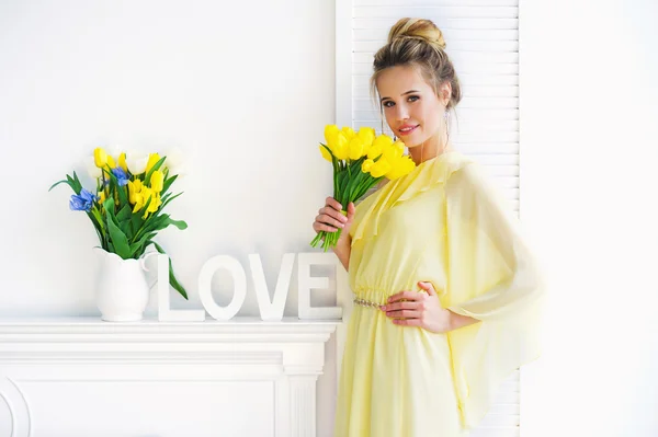 Woman with yellow tulips — Stock Photo, Image