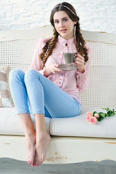 Mujer en sofá con taza de café — Foto de Stock