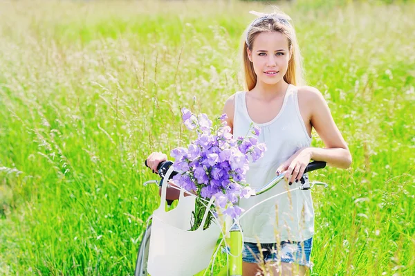 Hermosa joven con su bicicleta de crucero — Foto de Stock