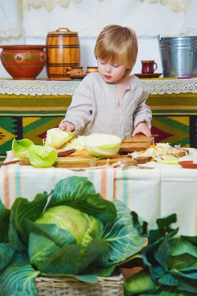 Junge kocht Gemüse in ländlicher Küche — Stockfoto
