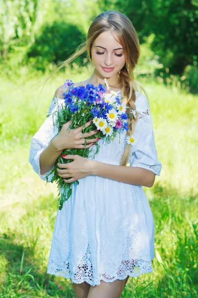 Gelukkige vrouw wit bouquet van chamomiles en korenbloemen — Stockfoto