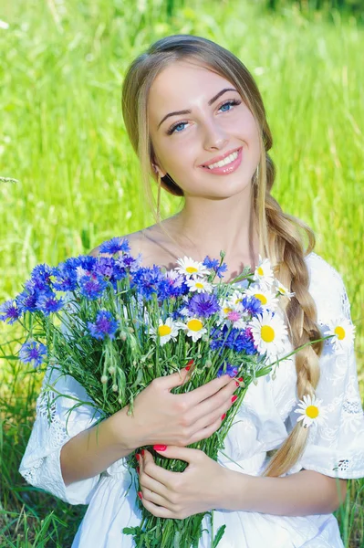 Happy woman wit bouquet of chamomiles and cornflowers — Stock Photo, Image