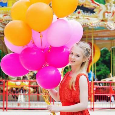 Renkli balonlarla gülümseyen genç model kadın