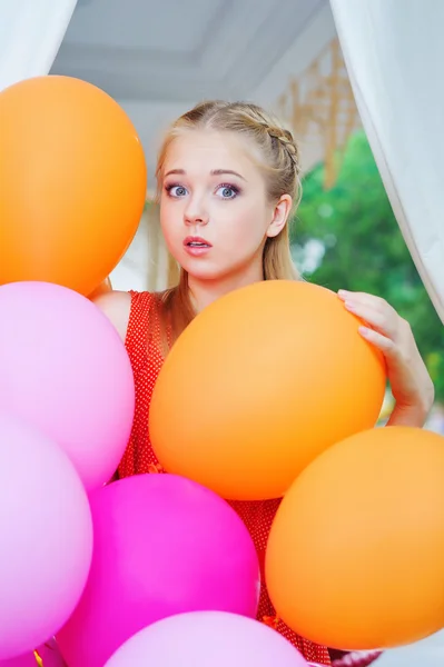 Surprised woman with with colorful balloons — Stock Photo, Image