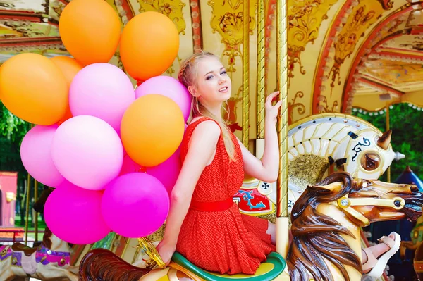 Young model woman riding a carousel — Stock Photo, Image