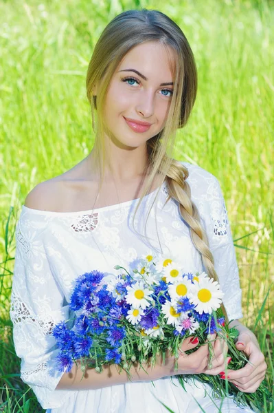 Gelukkige vrouw wit bouquet van chamomiles en korenbloemen — Stockfoto