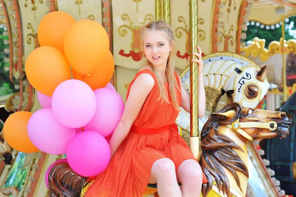 Young model woman riding a carousel — Stock Photo, Image