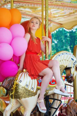 Genç kadın bir atlıkarınca üstünde poz