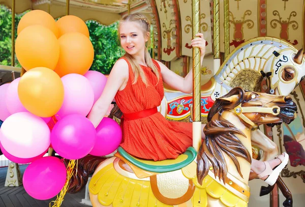 Young model woman riding a carousel — Stock Photo, Image