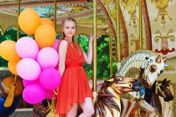 Young woman posing on a carousel — Stock Photo, Image