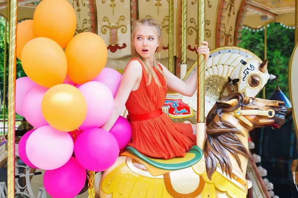 Young model woman riding a carousel — Stock Photo, Image