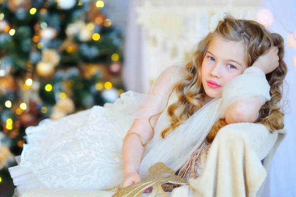 Schattig meisje door de kerstboom — Stockfoto