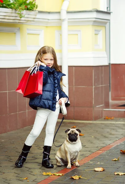 购物袋和她的狗的可爱女孩 — 图库照片