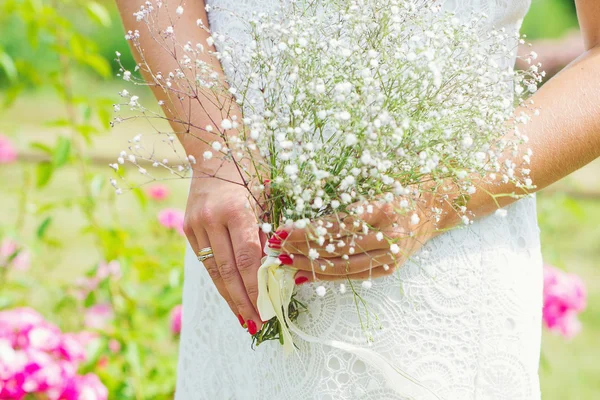 Woman manicured hands holding white flowers — Stock Photo, Image