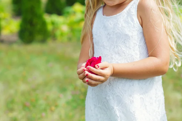 Bloemenmeisje handen vol met bloemblaadjes — Stockfoto