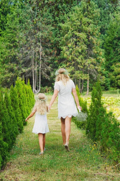 Mother and daughter walking rear view