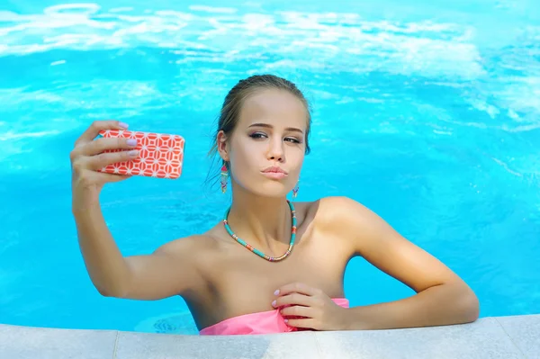 Linda jovem mulher tirando foto de si mesma na piscina — Fotografia de Stock
