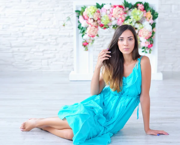 Retrato de una hermosa joven con fondo floral — Foto de Stock