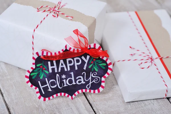 Still life with Happy Holidays sign and present boxes — Stock Photo, Image